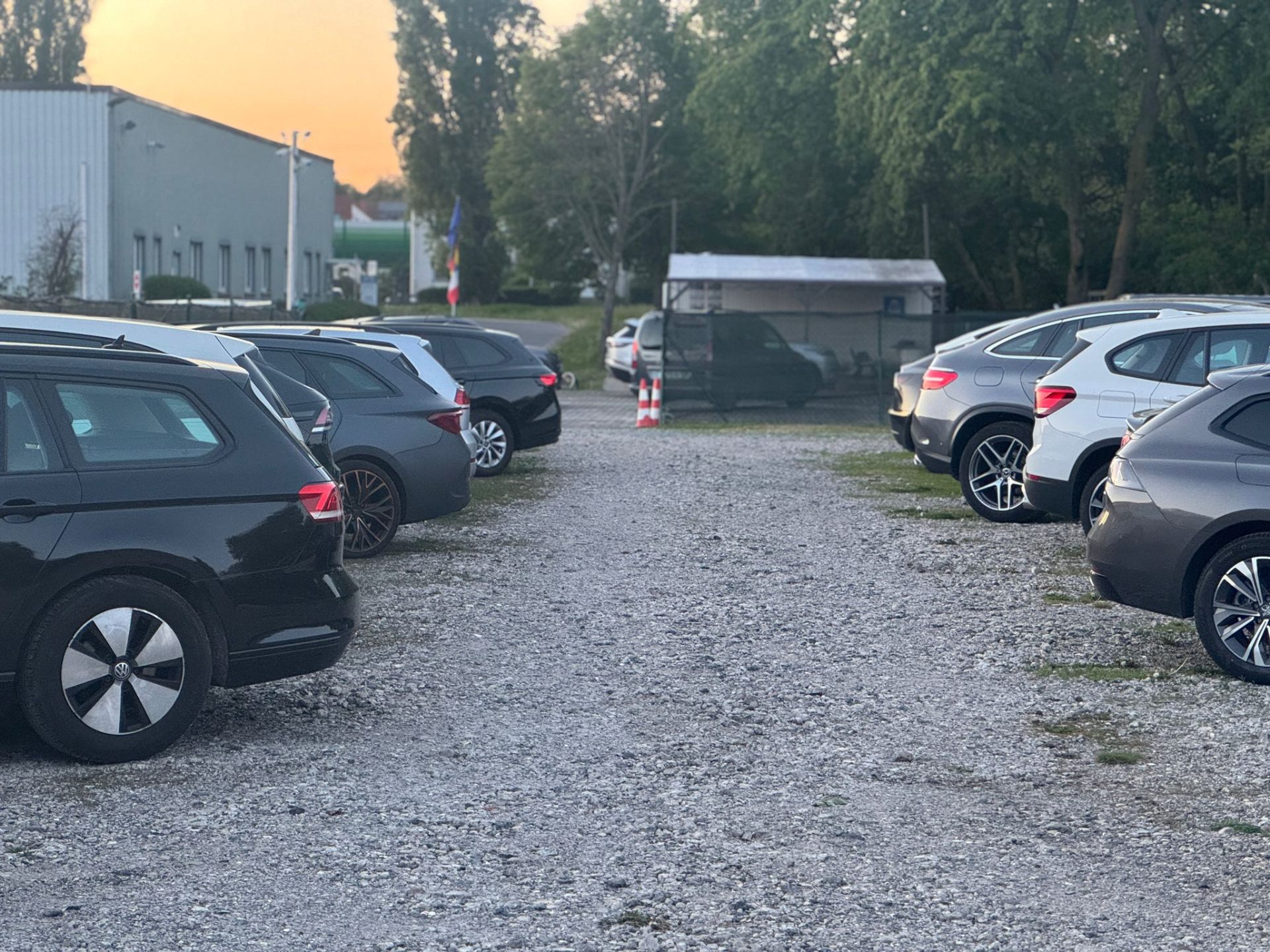 Bewachter Parkplatz in der Abenddämmerung mit geparkten Fahrzeugen